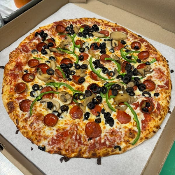 A whole Clarksburg Pizza Co. pizza with pepperoni, mushrooms, black olives, and green peppers.